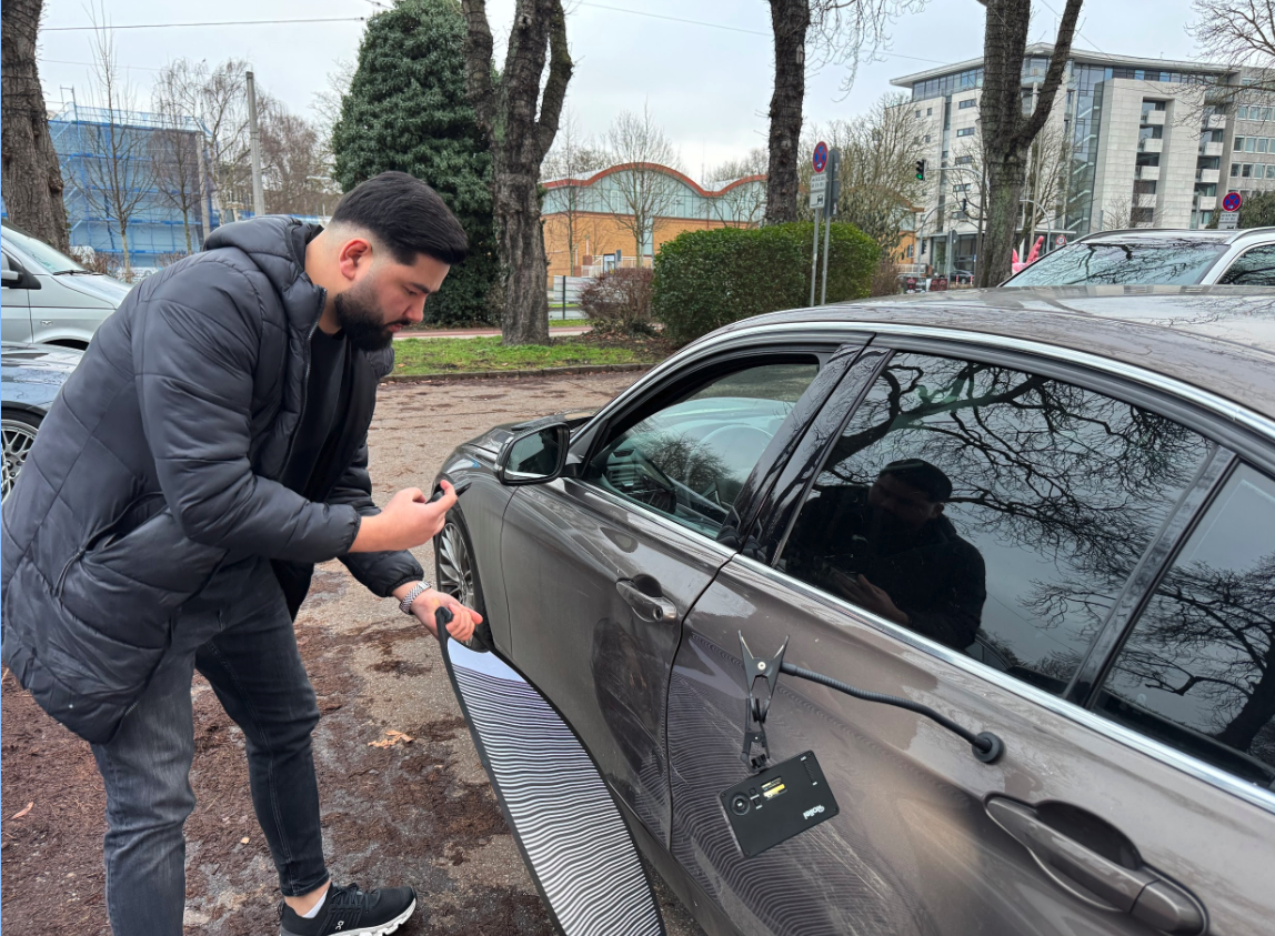 Kfz-Sachverständiger bei der Schadenaufnahme an einem Fahrzeug vor Ort